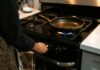 crop faceless woman adjusting rotary switch of stove