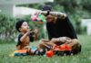 young father and son playing with toy cars outside